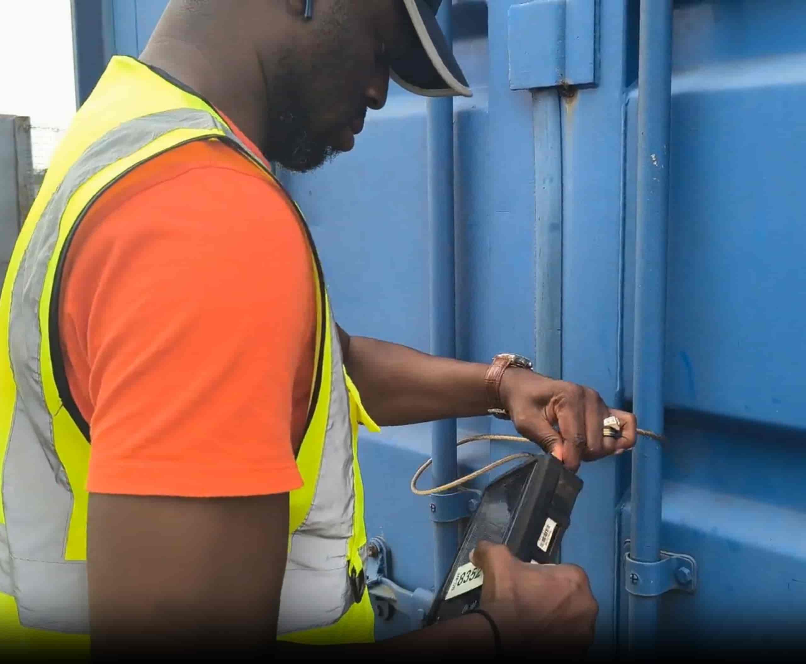 Technician fitting a Webb Transit Tracking device on a container door